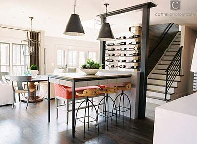 renovated kitchen area with wine rack, bar seating and stairs